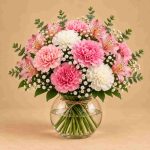 Pink and white carnations with pink alstroemeria, baby's breath and eucalyptus in a rounded glass vase