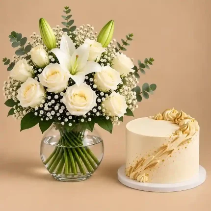 White roses and lilies with baby's breath and eucalyptus in a clear glass vase paired with a vanilla cake