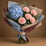 Blue hydrangea and blush-pink carnations with fresh greenery in blue-grey and maroon wrapping