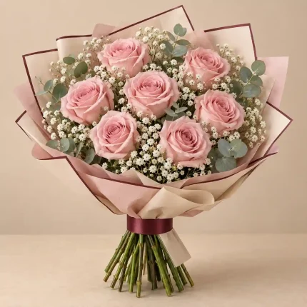 Blush pink roses with delicate white flowers and fresh greenery in beige and pink wrapping