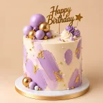 Ivory brushstroke birthday cake with edible gold leaf, gold and pearl dragées, chocolate spheres and gold Happy Birthday topper