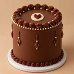 Luxury chocolate birthday cake with piped details, heart centerpiece and ivory and gold accents