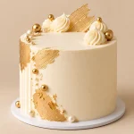 Ivory and gold luxury celebration cake with cream swirls, pearl accents and elegant gold detailing