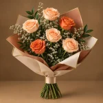 Seven peach and orange roses with white filler flowers and fresh greenery in cream and peach wrapping