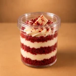 Red velvet cake jar layered with cream cheese frosting, red velvet crumbs and white chocolate garnish