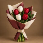 Red and white tulip bouquet with fresh green foliage and elegant wrapping